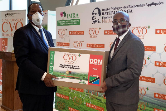 Madagaskar 8.5.2020:
                  Die Aussenminister von Tansania (Kabudi) und
                  Madagaskar (Djacoba) präsentieren eine Kiste mit dem
                  Heilmittel Covid Organic CVO gegen Corona19