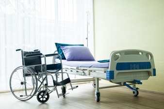 Krankenbett und Rollstuhl warten
