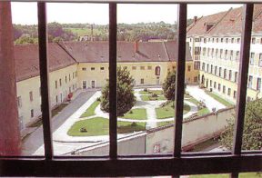 Der
                          Gefängnishof (Spazierhof) des Gefängnisses
                          (Justizanstalt) von Garsten (Österreich), mit
                          Rasen, Bänken und Wegen in anregender
                          Kreisform (Mandala), mit kleinen
                          Blumenbeeten.