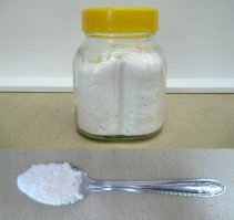Sodium bicarbonate in a glass and on a spoon