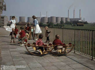 Kinderkrippe in der DDR mit Ger�ten neben
                        einem Kohlekraftwerk in Vetschau