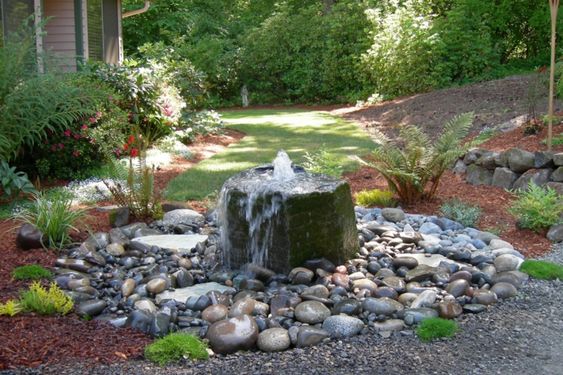 Quellstein mit Wasserfall im Garten