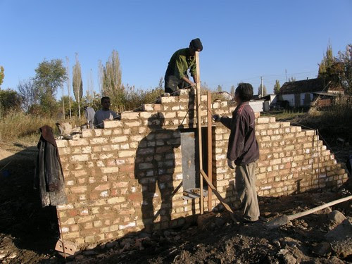 Kirgisistan 2010: Bau eines Walipinis
                              in der Fläche mit Doppelmauern rund rum,
                              Seitenmauer mit Fenster