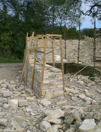 Construction of a freestanding dry
                            stone wall with wooden frame for the tilt