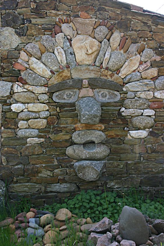 Arte
                                de piedra seca de diferentes piedras,
                                una cara de piedra