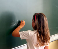Ein Kind schreibt an eine Tafel. Wenn Eltern
                    nicht mehr loben, ist das Lob der Lehrperson das
                    einzige Lob im Leben...