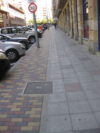 Trottoir in Platten:
                        Weiss mit roten Tupfern - und der Randbereich in
                        Gartensteinen gelb-rot-schwarz