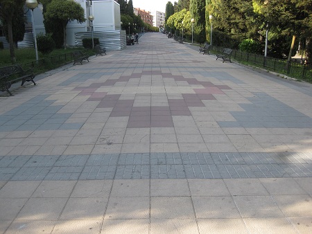 Jesuitenpark in
                        Salamanca, breiter Weg in Platten
                        gelb-rot-schwarz