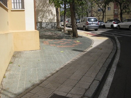 Kleiner Platz mit gr�nen Gartensteinen, rotem
                    Muster und gelbem Trottoir in gerillten Platten