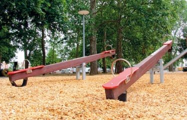Wippe 02 aus Holz mit
                            Gummipuffern auf einem Sgemehlboden,
                            Claramatte-Park, Basel
