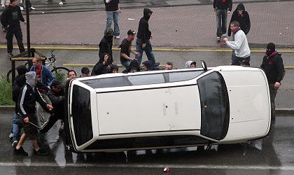 FCB-Krawalle vom
                        13.5.2006: Basler Schl�gertypen vor dem Stadion
                        sind dabei, ein Auto der Zivilpolizei
                        umzukippen