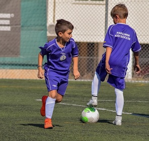Ni�os jugando
                  pelota f�tbol