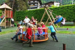 Carrusel infantil en un parque infantil del
                        Oberland bern�s con ni�os que juegan