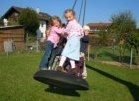 Reifenschaukel 20 mit
                            Boden, die Kinder stehen auf der Schaukel,
                            Kindergarten St. Vitus, Emertsham,
                            Deutschland