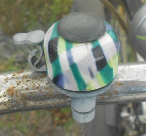 Vielfarbige Veloglocke /
                Fahrradklingel in Schwarz-Gr�n-Weiss